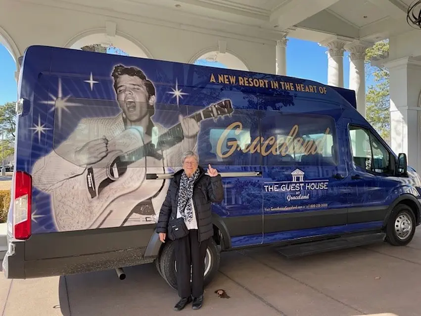 Lucienne is posing in front of Graceland's van wrapped with Elvis's photo / Lucienne pose devant la camionnette de Graceland sur laquelle figure la photo d'Elvis