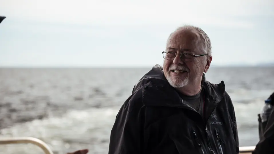 Senior man enjoying the view of wavy waterbody / Homme âgé profitant de la vue sur un plan d'eau ondulé